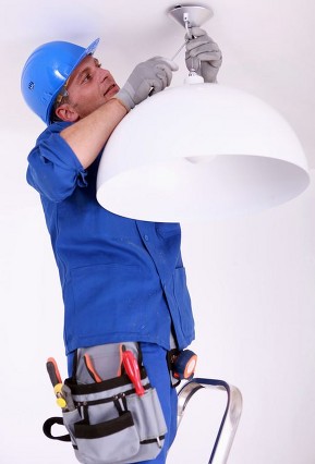 Worker maintaining a light fitting